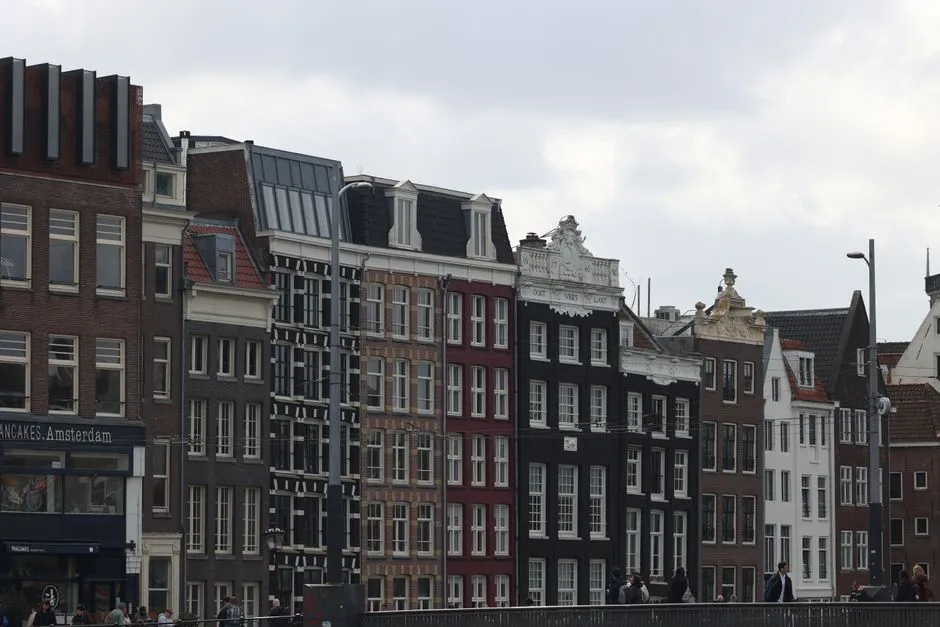 Eine Reihe hoher, schmaler Grachtenhäuser im Zentrum Amsterdams, jedes mit eigenem Giebel und eigenem Eingang