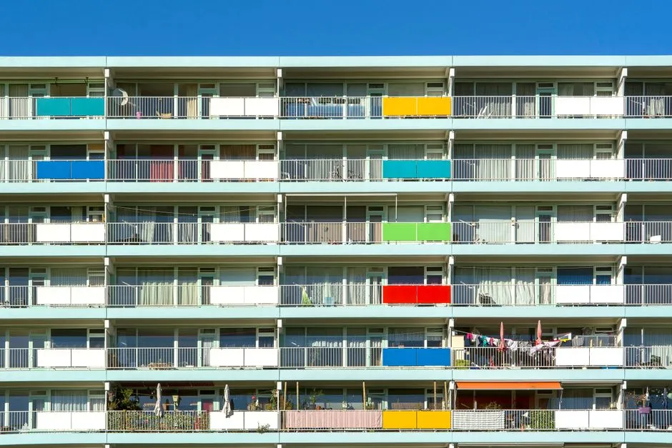 Un colorido bloque de viviendas neerlandés con balcones pintados de diferentes colores vivos, típico del parque de vivienda social gestionado por las cooperativas de vivienda de Ámsterdam