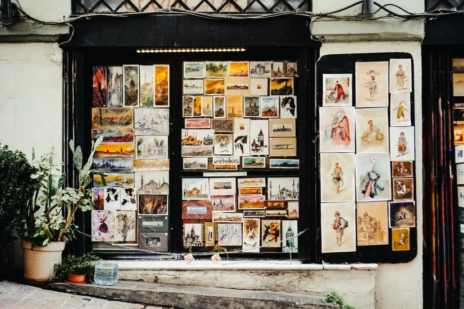 A shop window in a Berlin neighborhood entirely covered with dozens of small framed artworks and illustrations