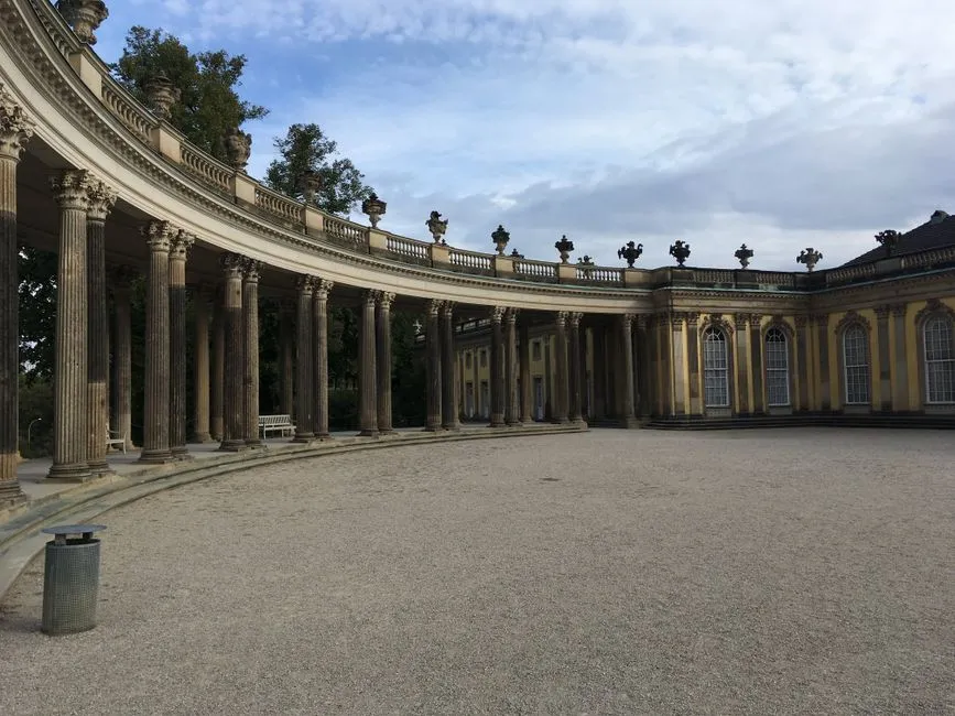 La columnata curva y el patio del Palacio de Sanssouci en Potsdam, un destino habitual de excursión de un día desde Berlín, sin visitantes visibles