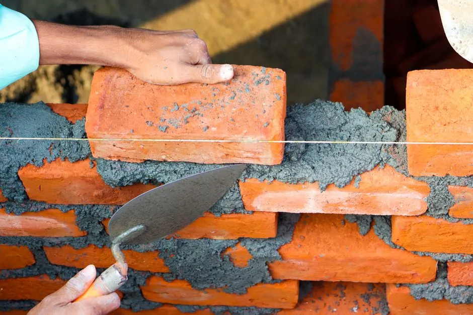 Una paleta de techador de pizarra, una línea de tiza, y un rollo de chapa de cobre dispuestos sobre tablones de madera envejecidos