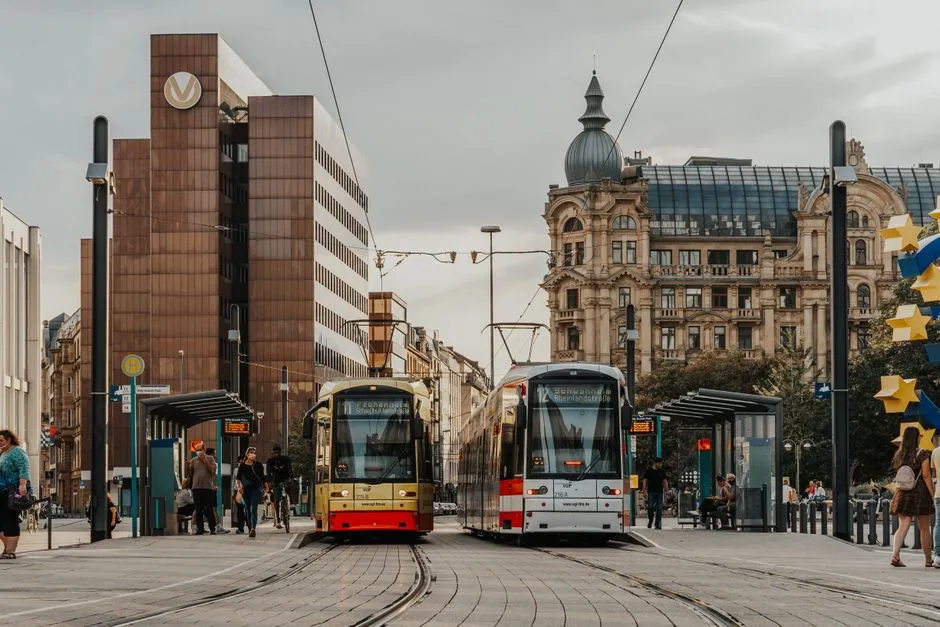 Zwei RMV-Straßenbahnen an einer Haltestelle in der Frankfurter Innenstadt, mit wartenden Fahrgästen auf dem Bahnsteig