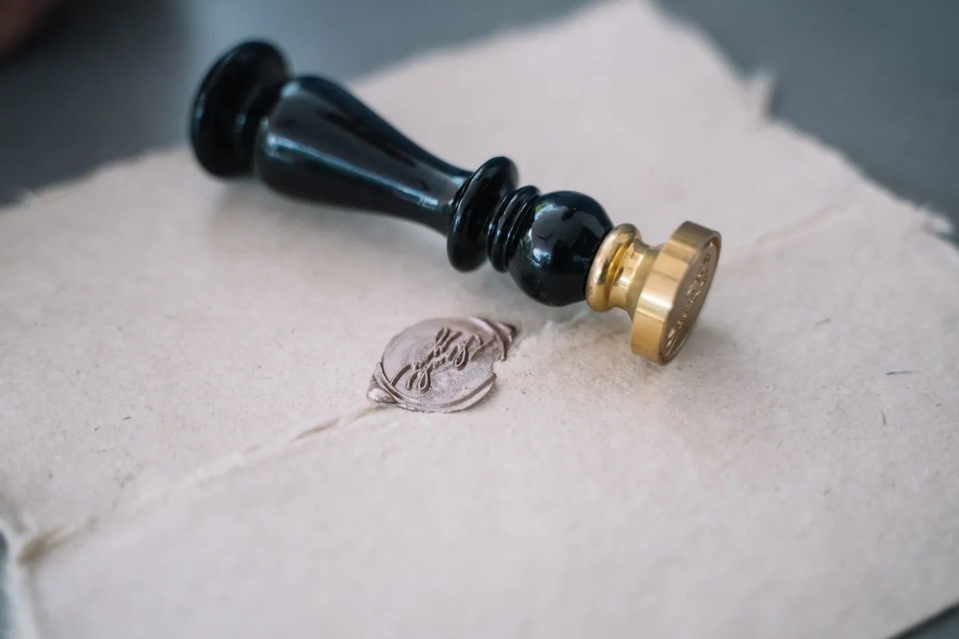 Close-up of a wax seal stamp pressed onto textured paper, evoking official document certification