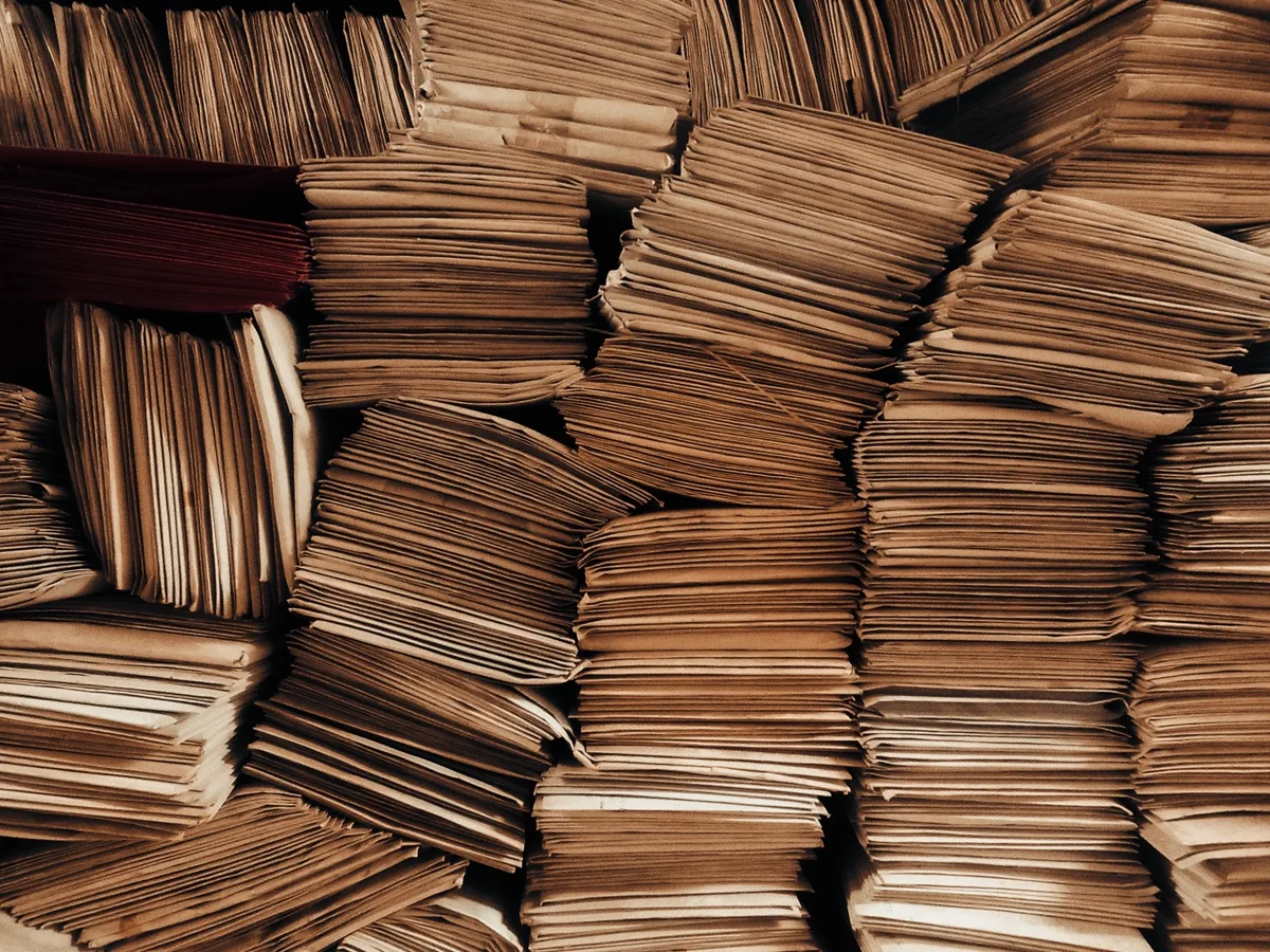 Stacks of neatly bundled paper envelopes and case folders, viewed from above, with no visible text or faces