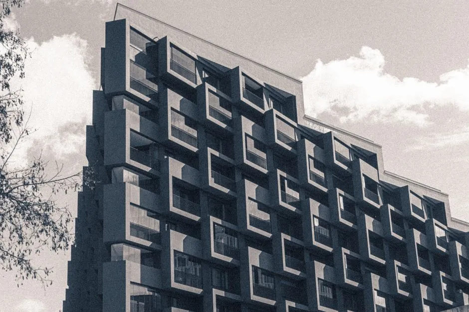 Vista de ángulo bajo de la fachada de un edificio de apartamentos modernista de varias unidades en Hamburgo con un patrón en zigzag apilado de balcones y ventanas individuales