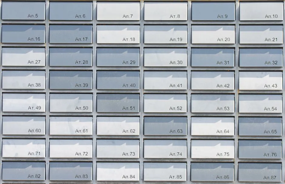 Una cuadrícula simétrica de buzones numerados de un edificio de apartamentos con ranuras de correo estrechas