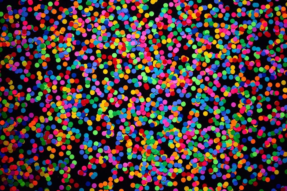 Confeti colorido esparcido densamente sobre un fondo oscuro