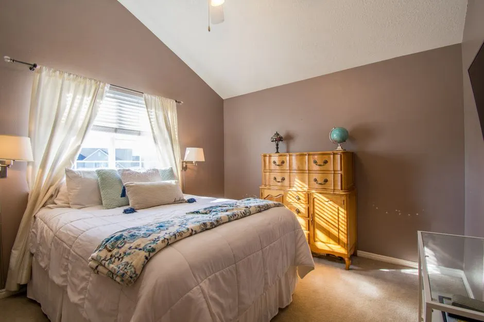 Un dormitorio ordenado y amueblado con una cama hecha y una cómoda, el tipo de habitación que se suele ofrecer bajo un acuerdo de hospitaverhuur