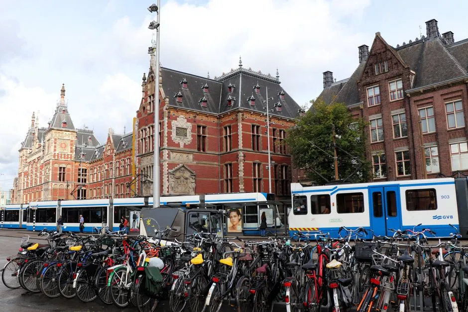 Filas de bicicletas aparcadas frente a un tranvía de GVB cerca de la estación de Ámsterdam Centraal